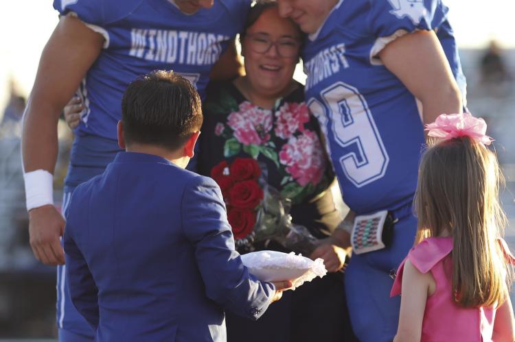 Windthorst Senior Harlee Johnston is embraced by Hayden Cavazos (left) and Eddie Vieth (right) after being named homecoming queen on Friday, Oct. 9. Photo/Rolando Medina