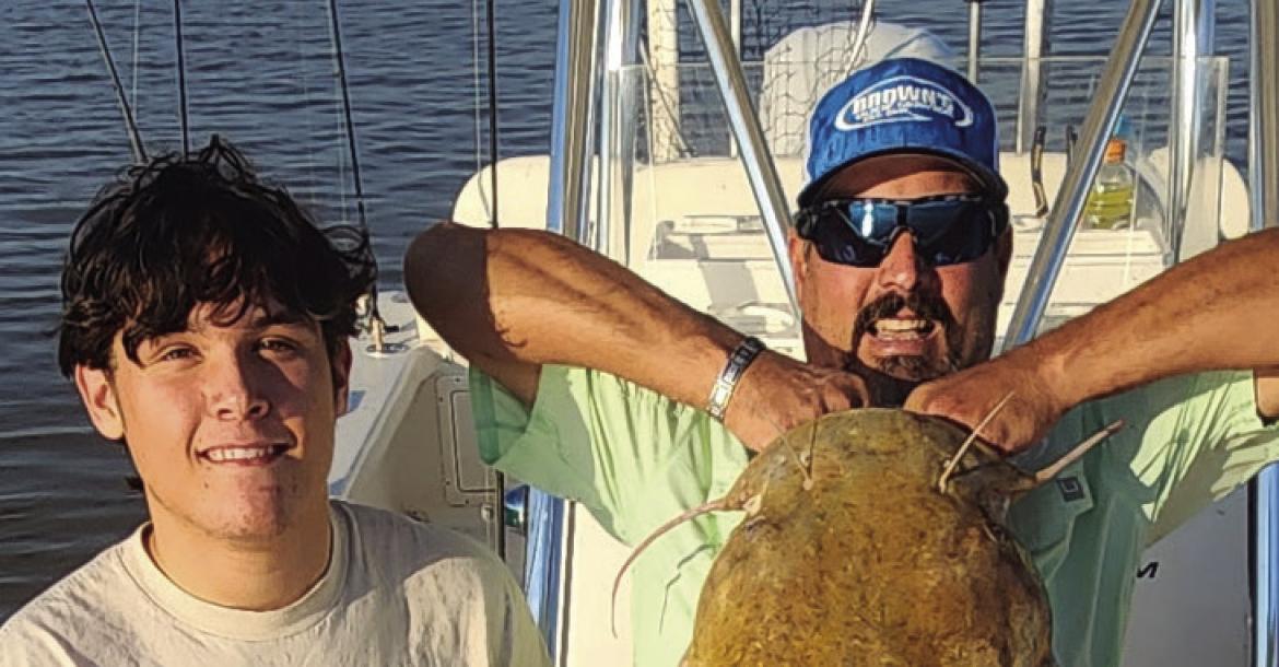 William Maxwell (left) and Brandon Brown poses with a record breaking 65.6 pound flathead catfish that Maxweel reeled in on Aug. 28. Courtesy photo