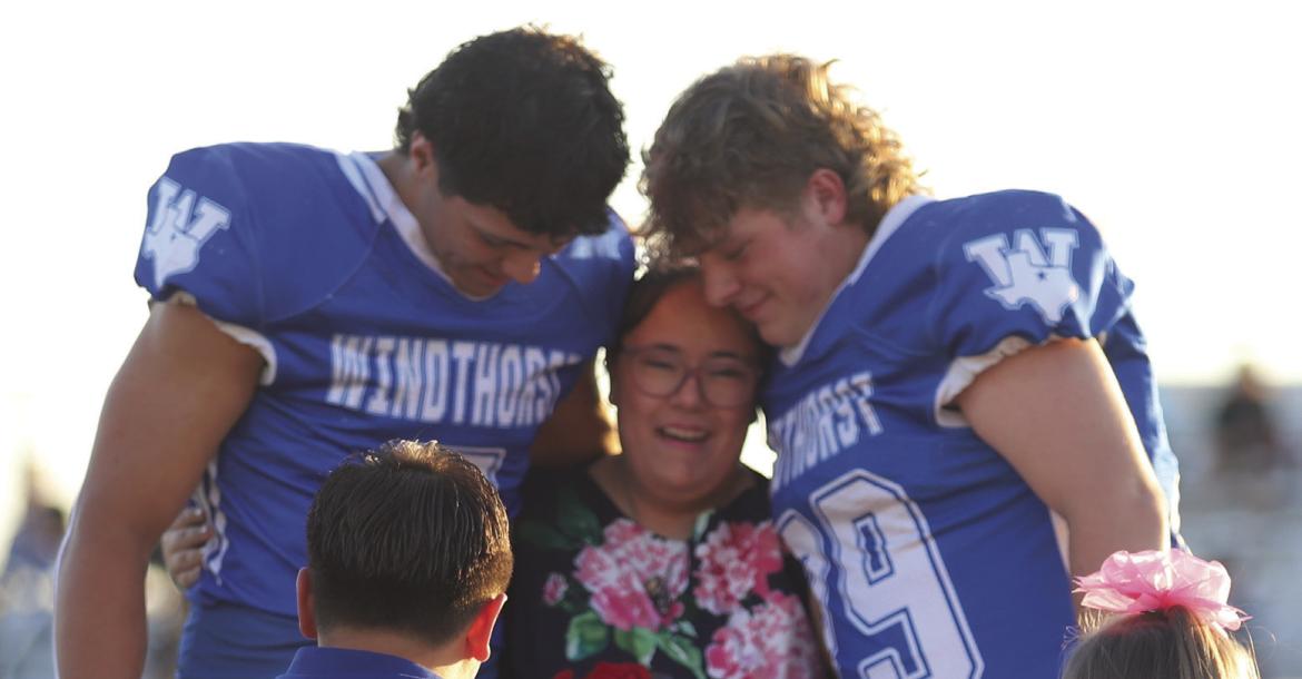 Windthorst Senior Harlee Johnston is embraced by Hayden Cavazos (left) and Eddie Vieth (right) after being named homecoming queen on Friday, Oct. 9. Photo/Rolando Medina
